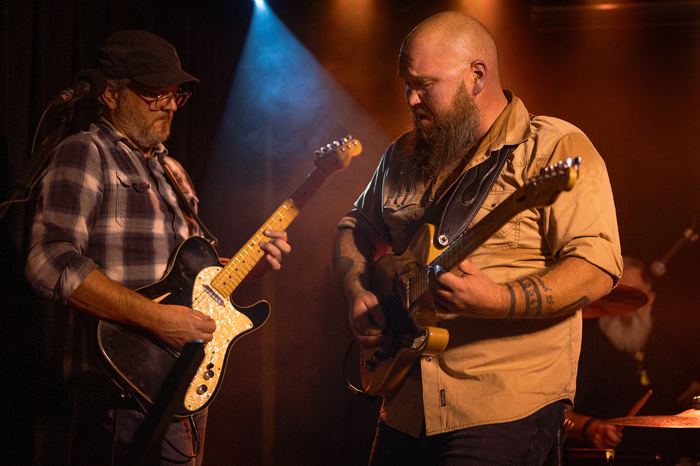 Ricky Ganiere and Ryan Elliott play guitars together.