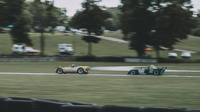 A 1973 Chevron B23 (#80) on the tail of a 1965 Genie Mk 10B (#17) as they accelerate hard out of turn 3 during Friday practice.