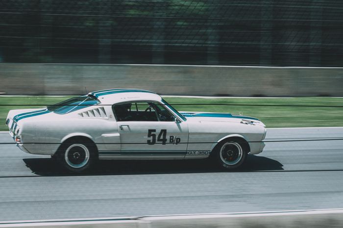 A 1965 Shelby GT350 roars through the woods at the end of the straightaway into turn 5 during Friday practice.